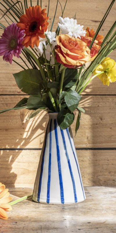 Photo grand vase bleu rayé blanc avec bouquet de fleurs